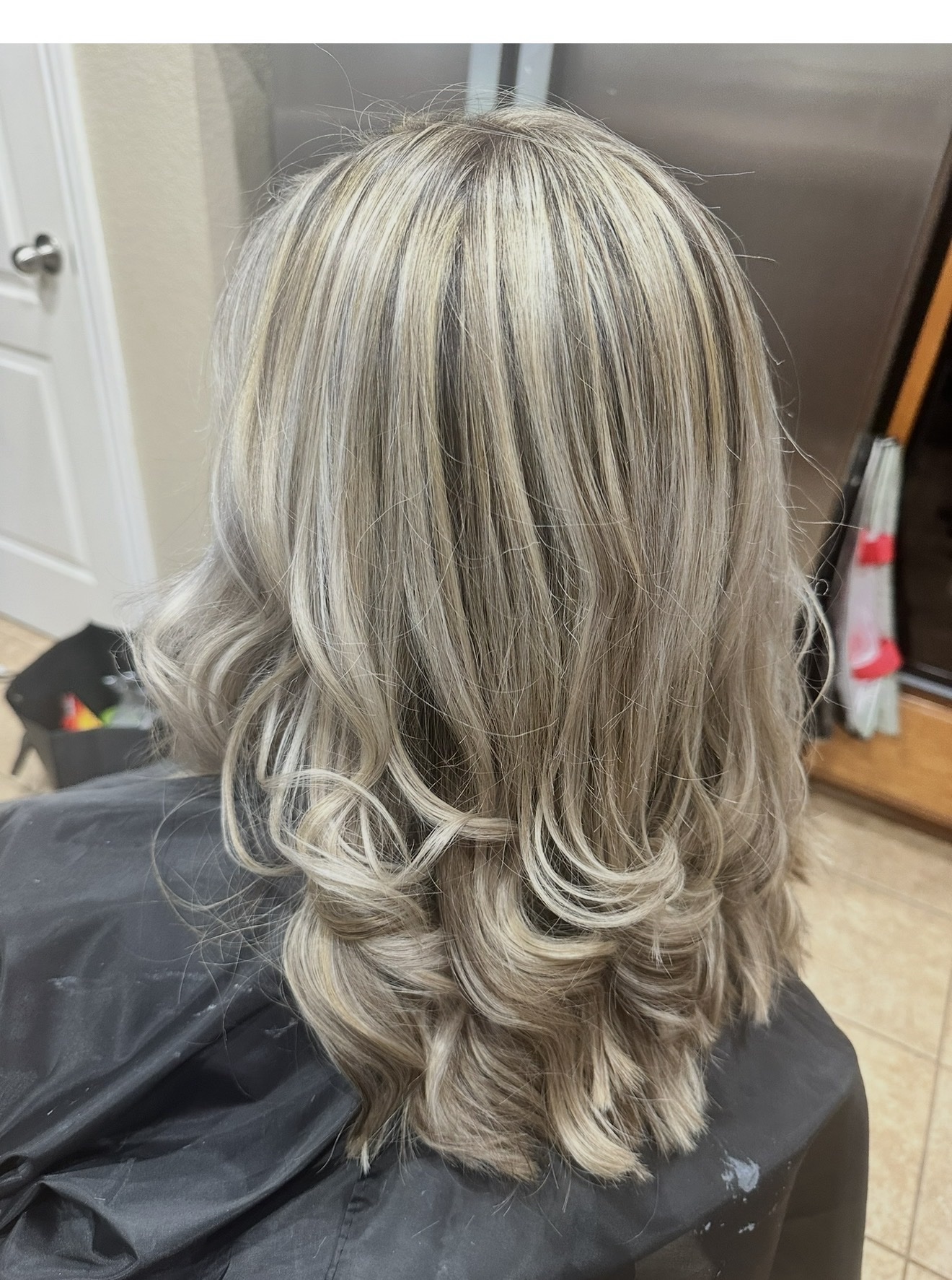 Ash blonde highlights styled with curled ends